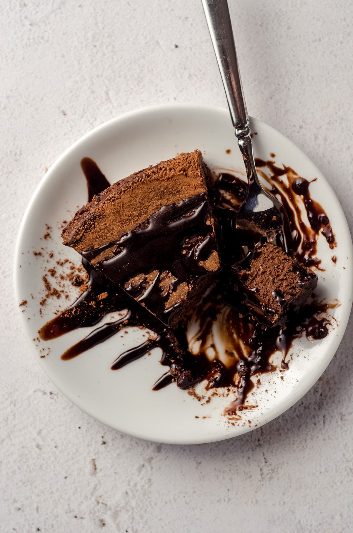 a slice of gluten free dairy free chocolate cake with chocolate syrup on it