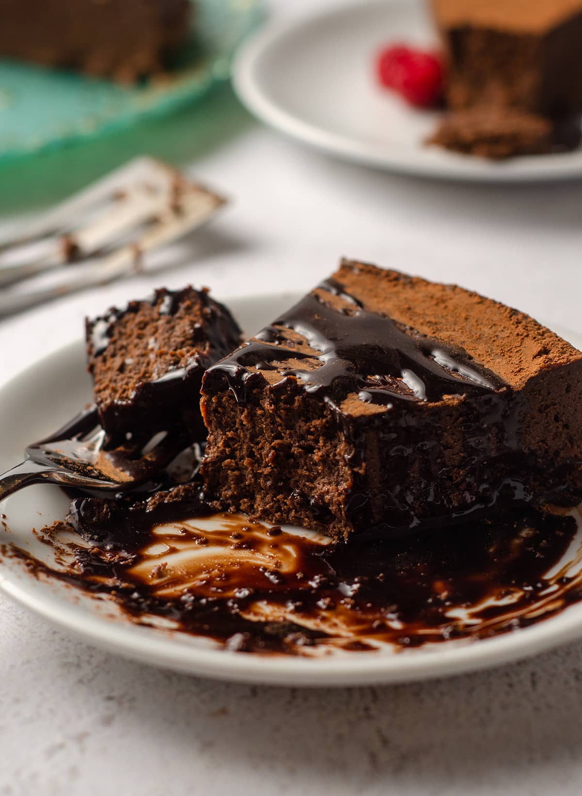 a slice of gluten free dairy free chocolate cake with chocolate syrup on it