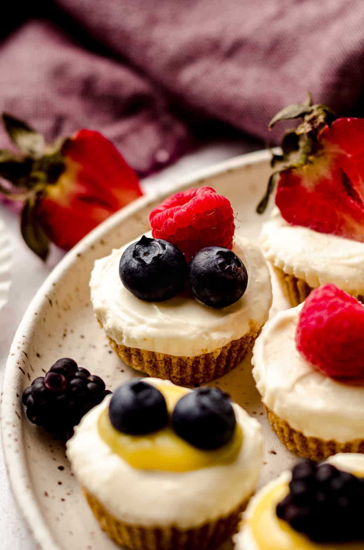 no bake cheesecake bites on a plate with fruit and lemon curd