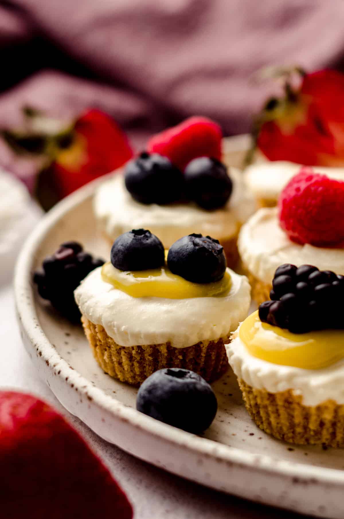 no bake cheesecake bites on a plate with fruit and lemon curd