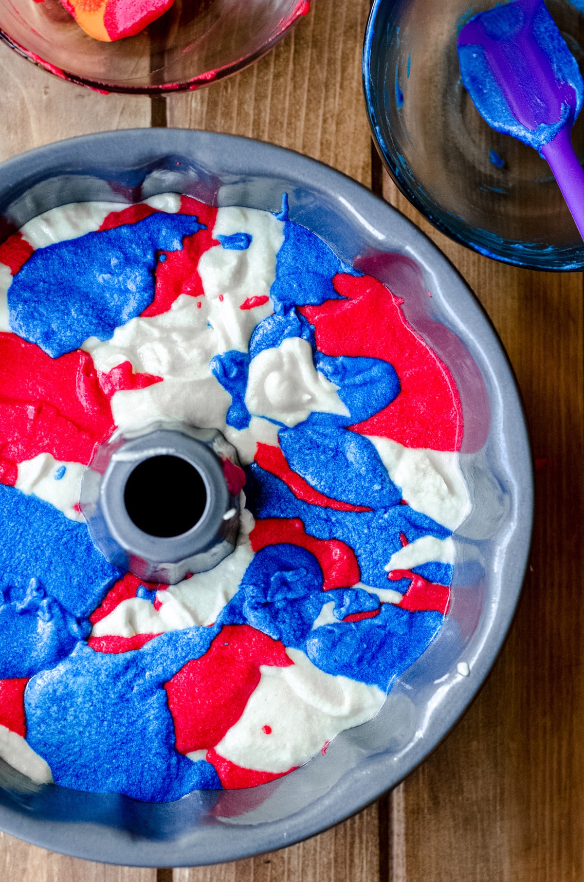 red white and blue swirl cake batter in a bundt pan