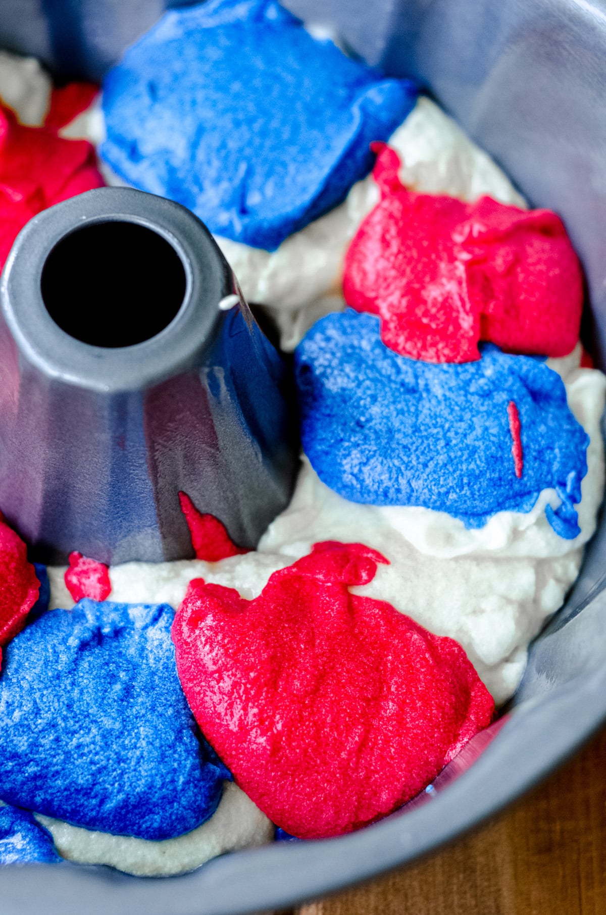 red white and blue swirl cake batter in a bundt pan