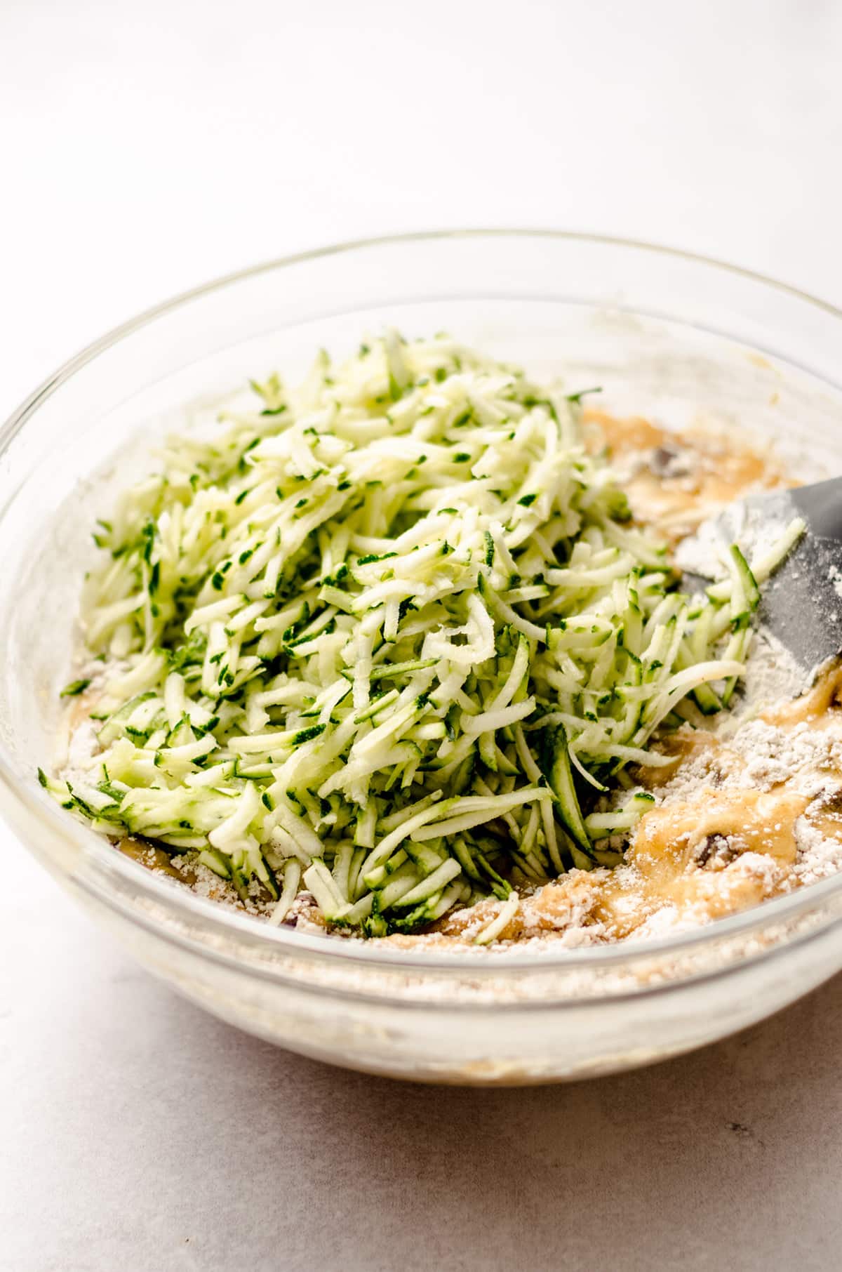 stirring shredded zucchini into chocolate chip zucchini bread batter