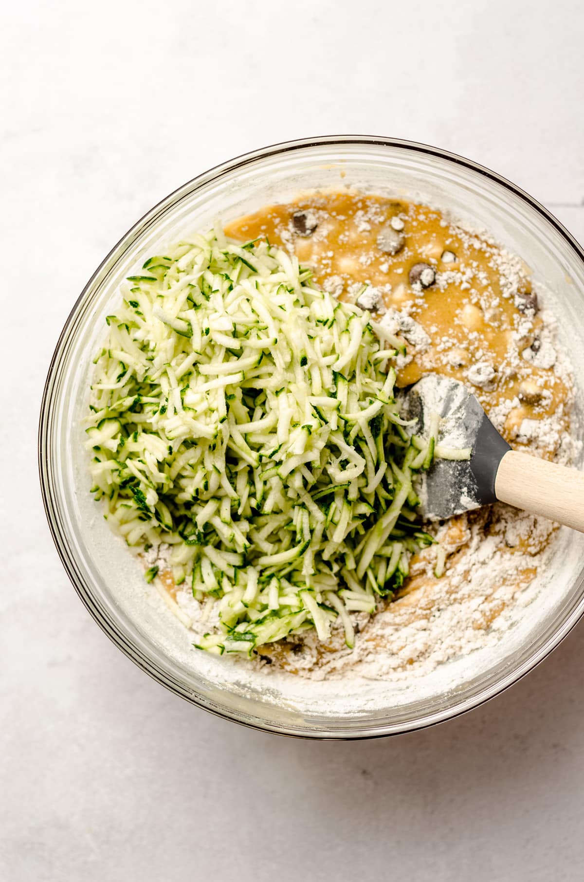 stirring shredded zucchini into chocolate chip zucchini bread batter