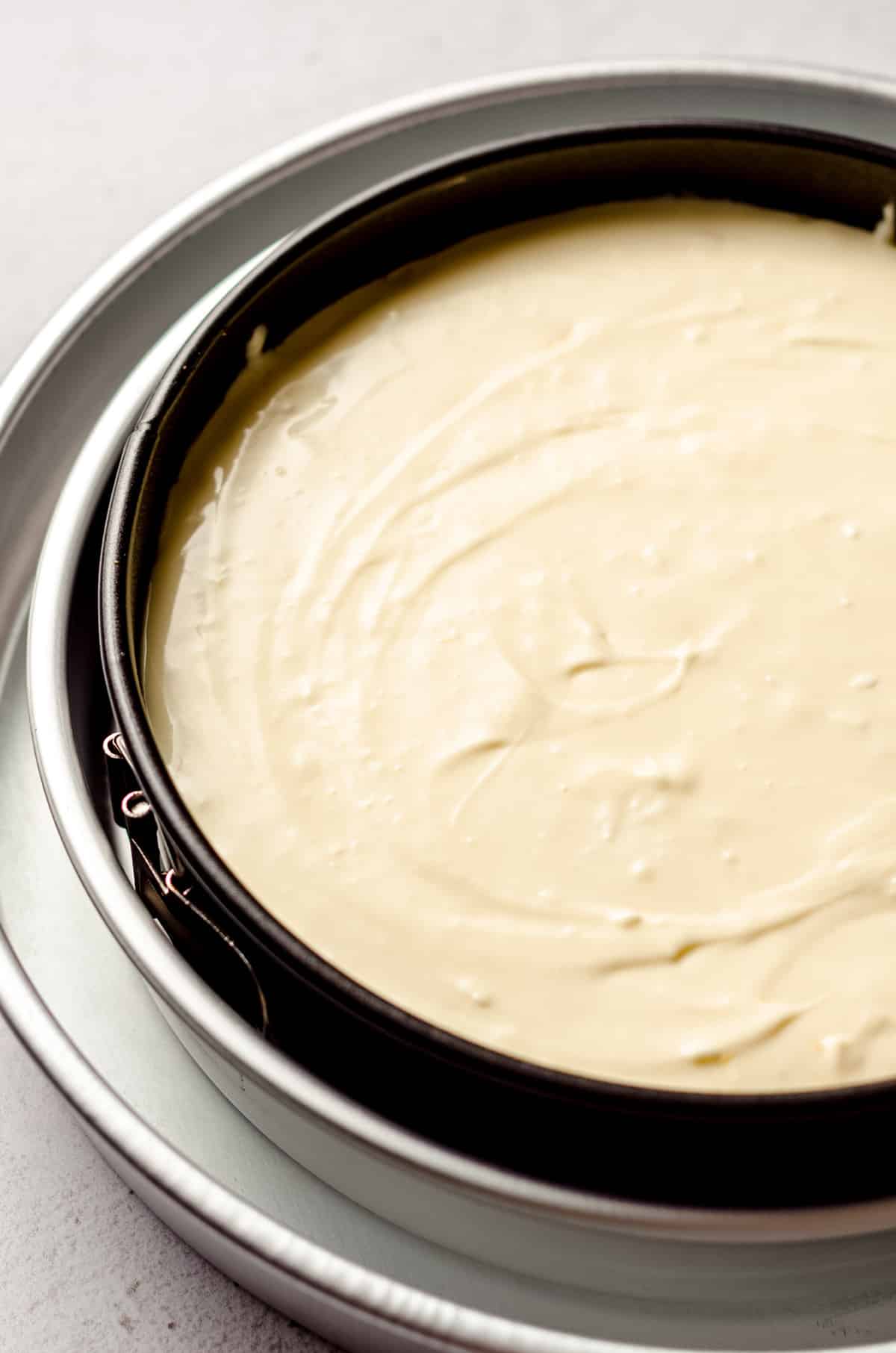 peach cheesecake batter in a pan