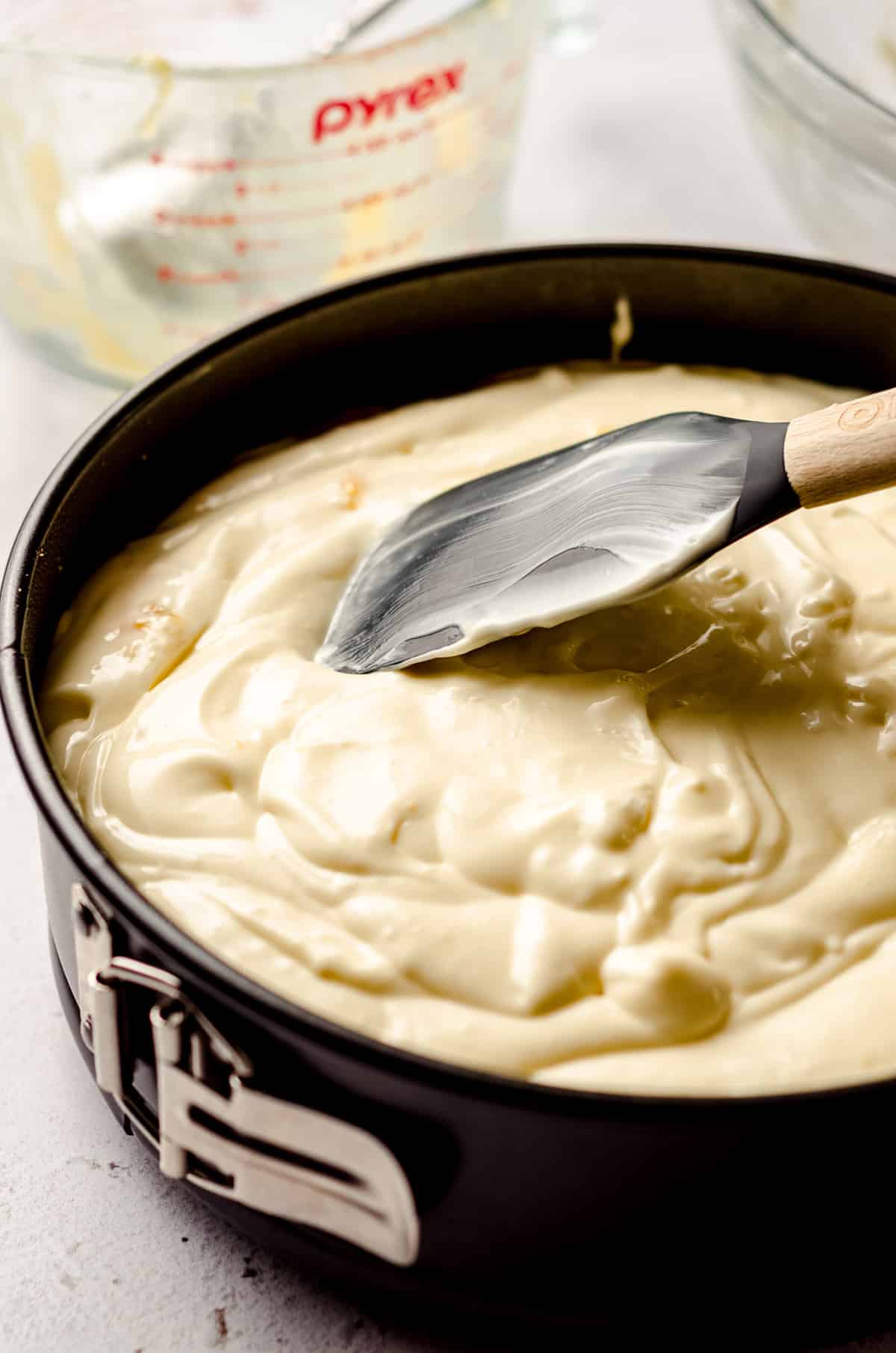 spreading peach cheesecake batter into a springform pan