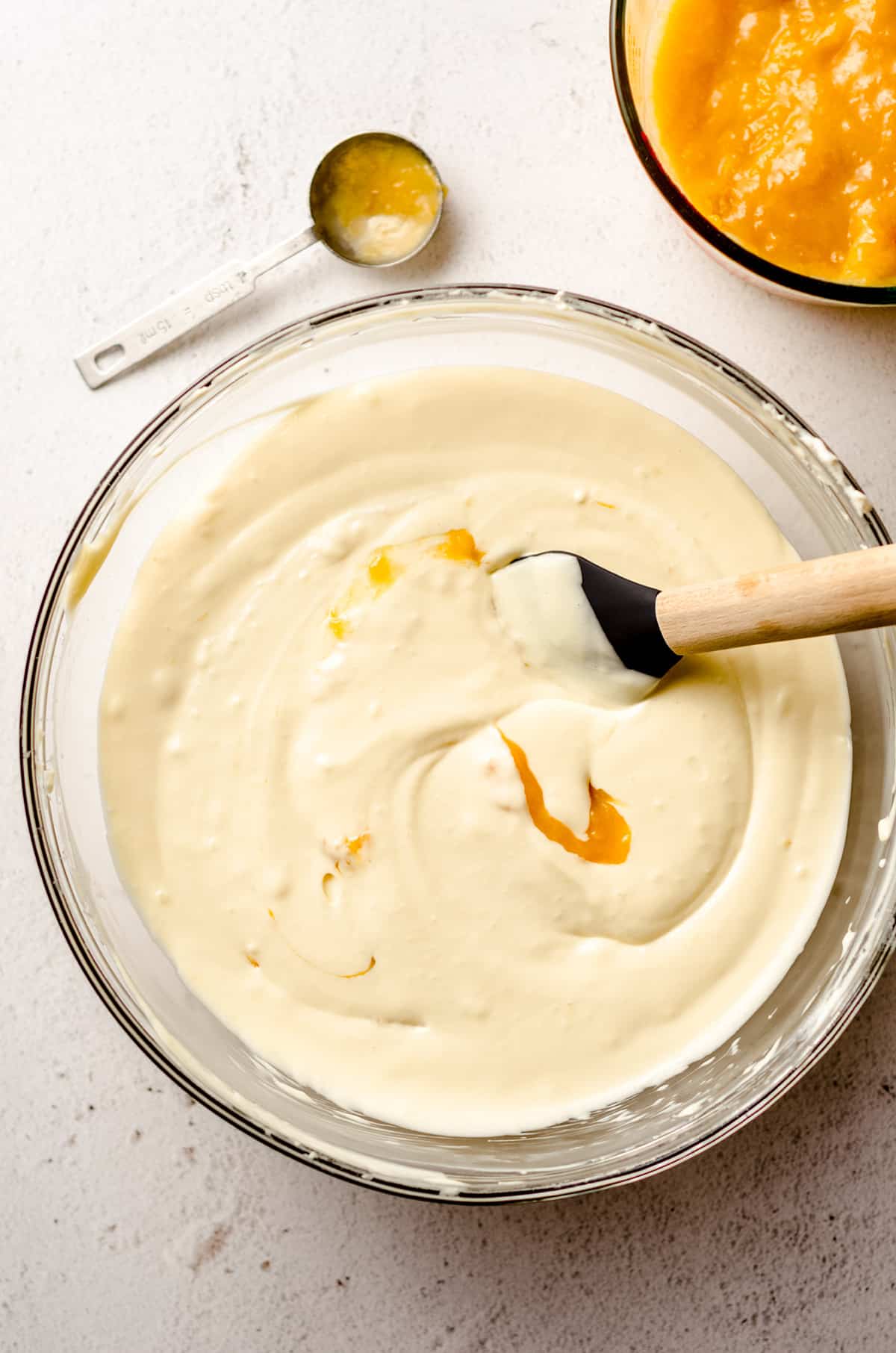 peach cheesecake batter in a large glass bowl