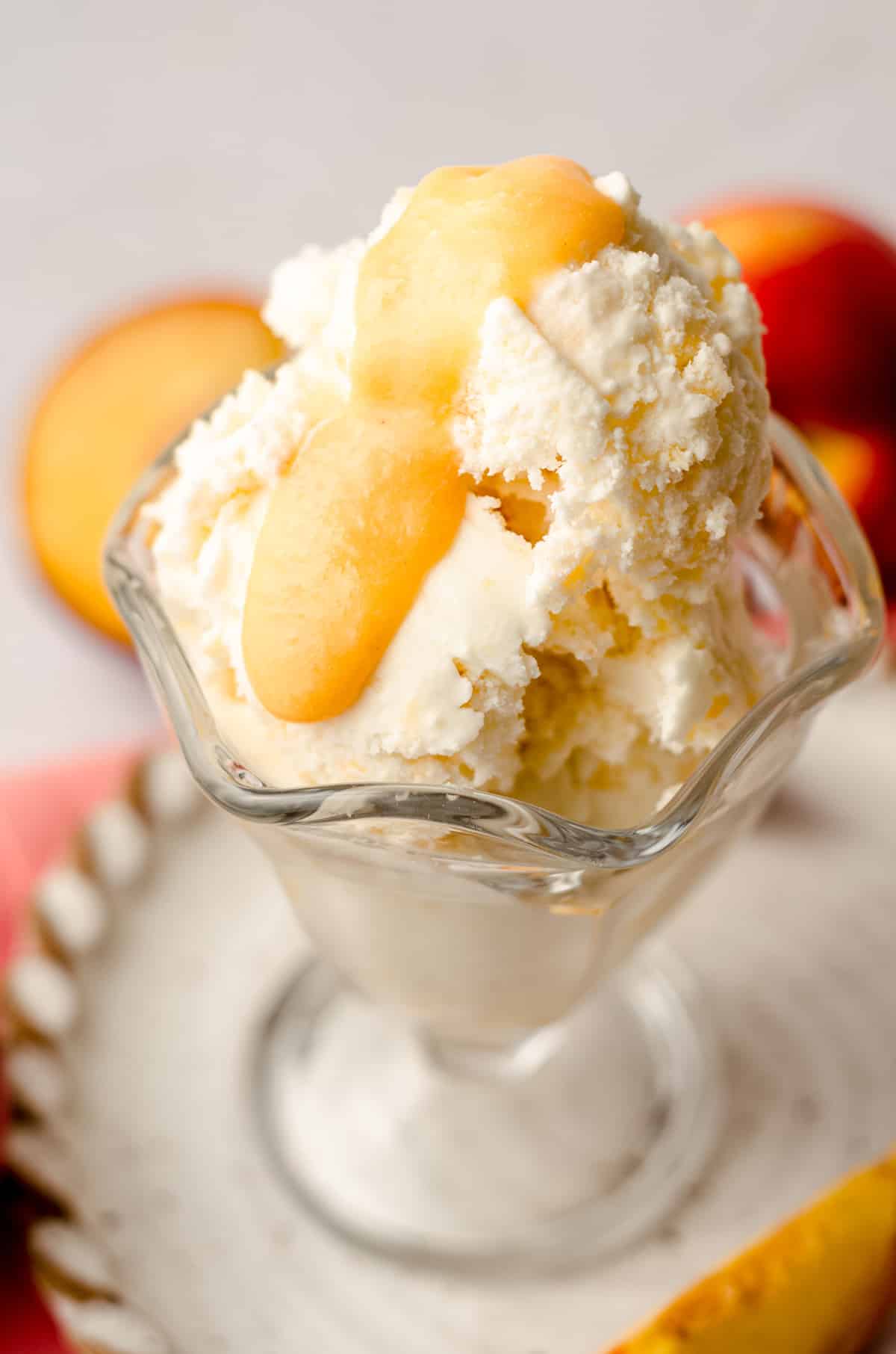 homemade peach ice cream in a glass dish with peach curd on top