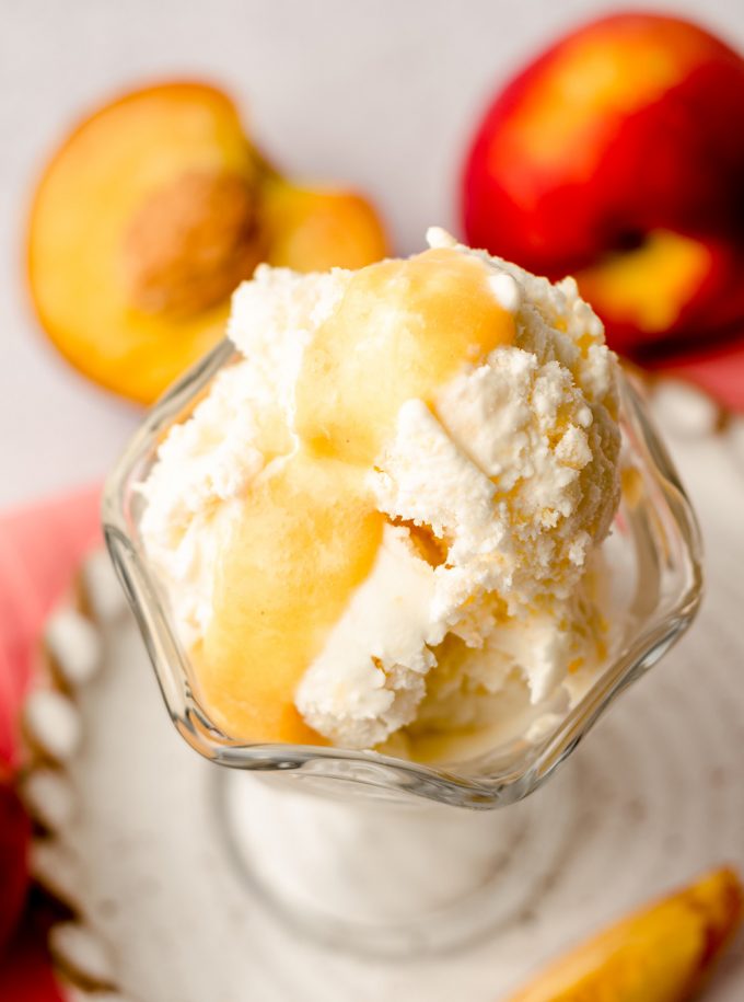 homemade peach ice cream in a glass dish with peach curd on top