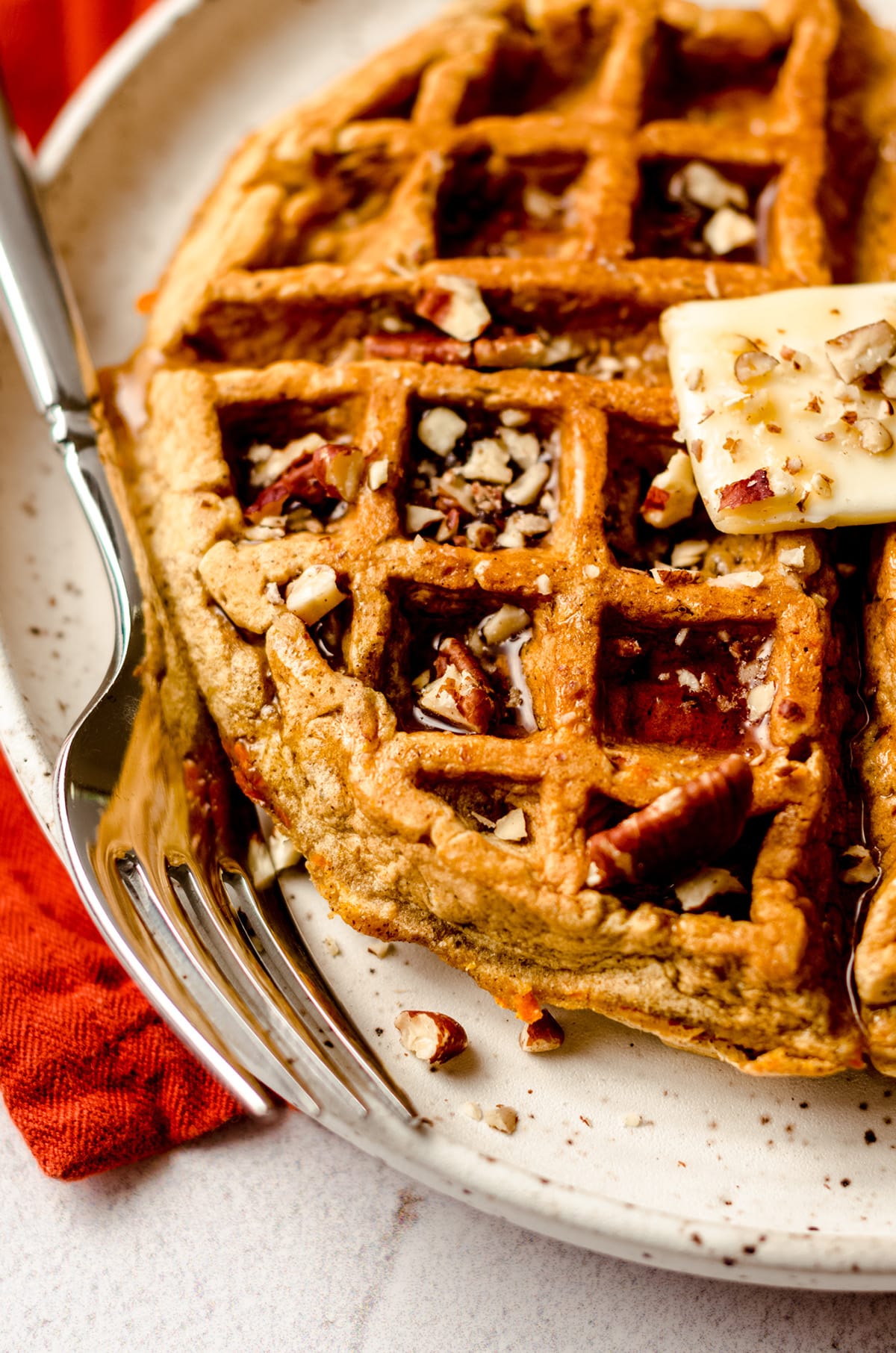 carrot cake waffle with a pat of butter and syrup on it