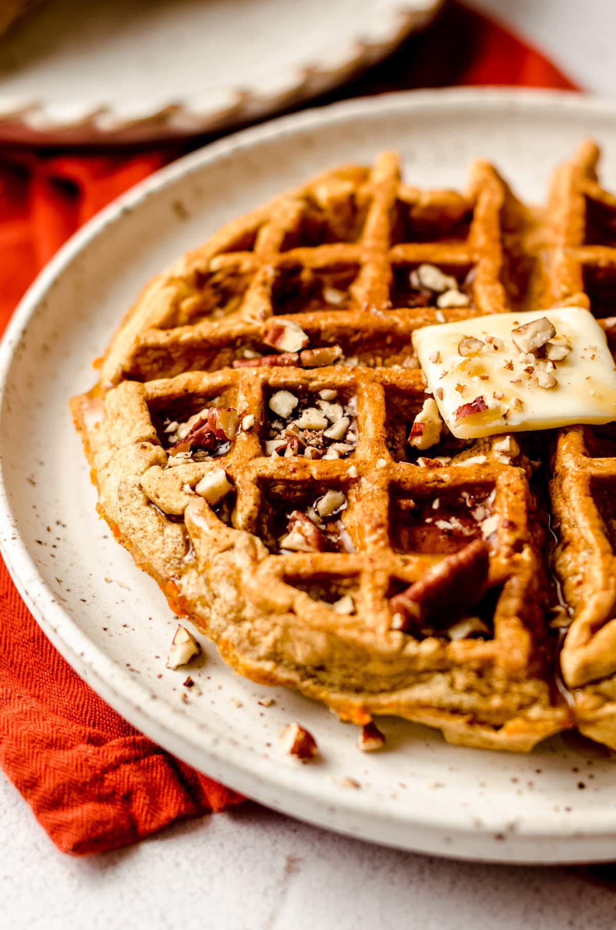 carrot cake waffle with a pat of butter and syrup on it