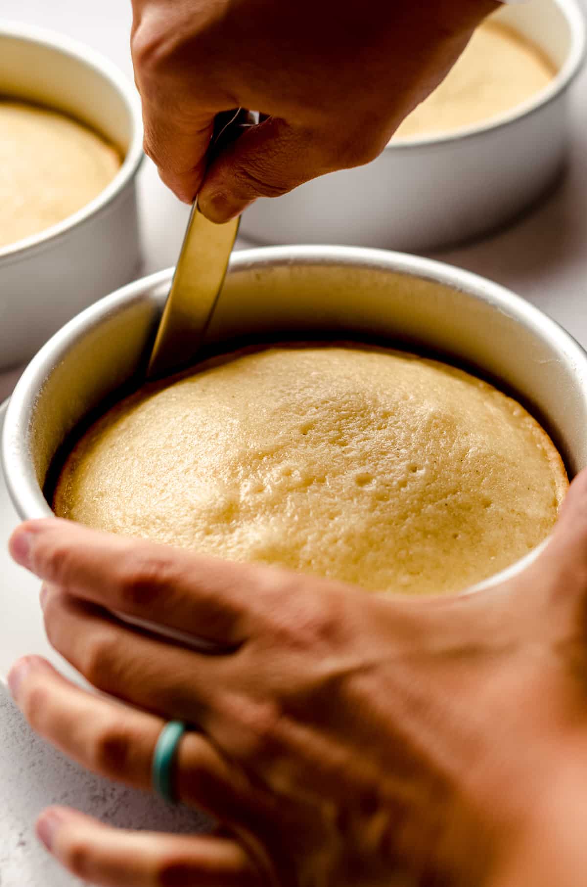 using a spatula to loosen a baked cake from a cake pan