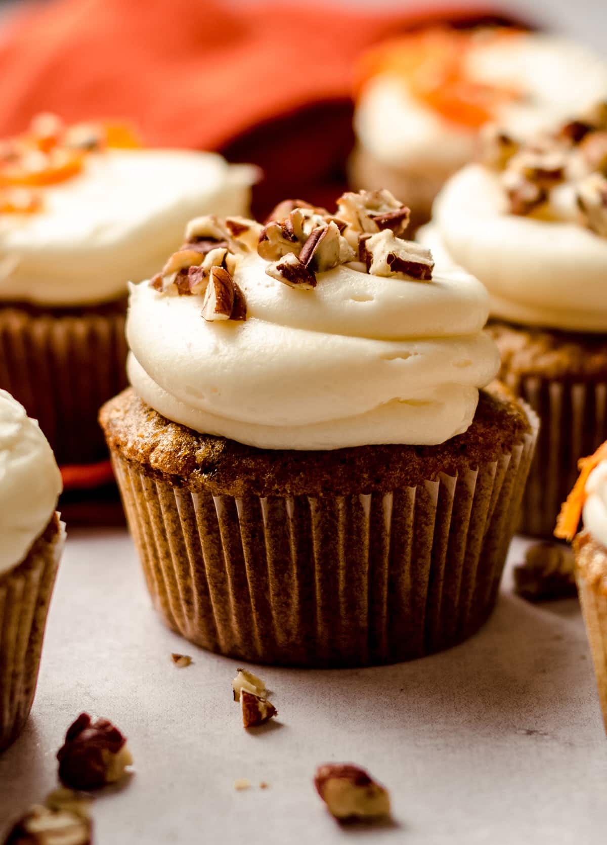 carrot cake cupcakes with cream cheese frosting with pecans on top