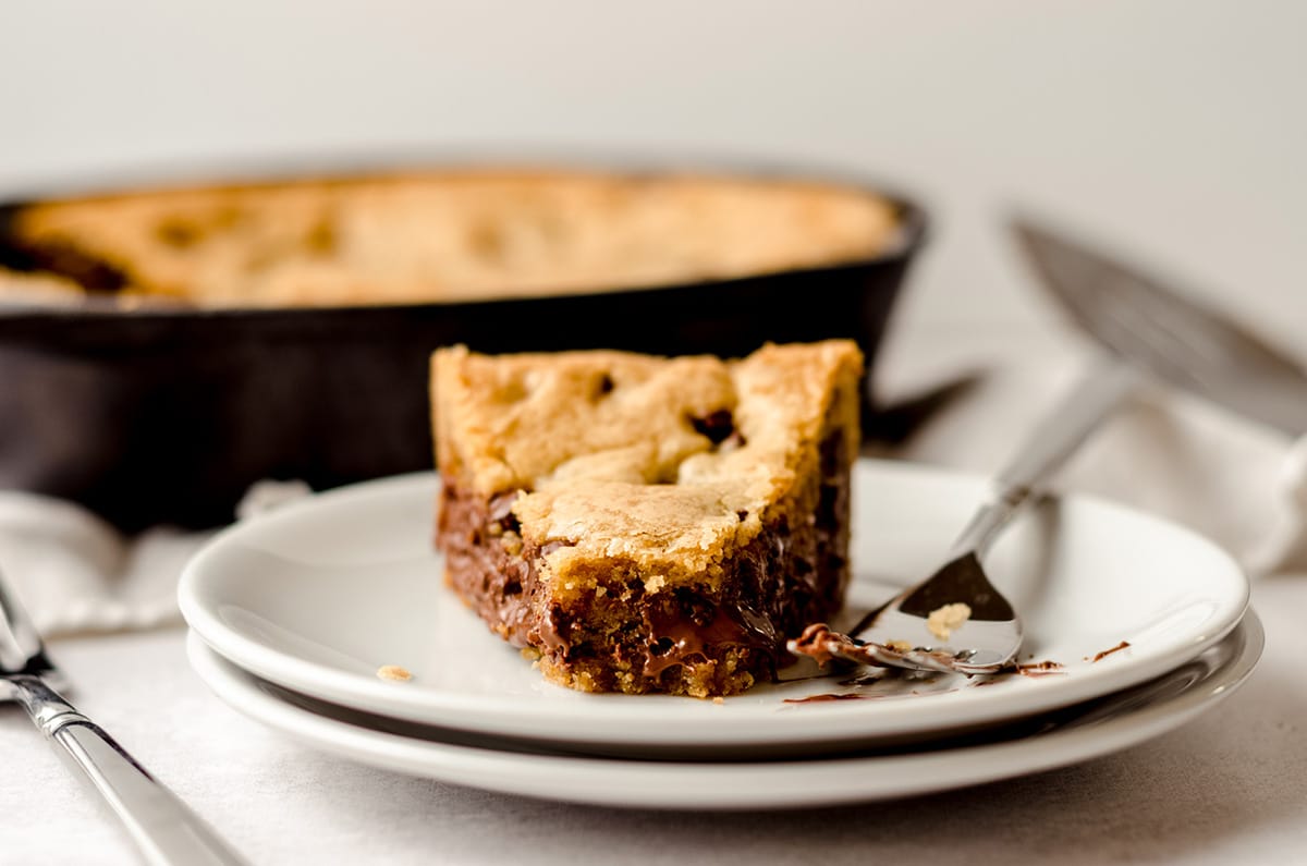 slice of nutella cookie cake on a plate with a bite taken out of it