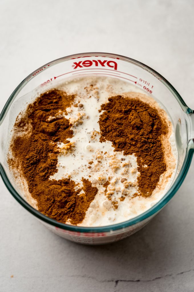 A large glass measuring cup full of ingredients to make pumpkin ice cream.