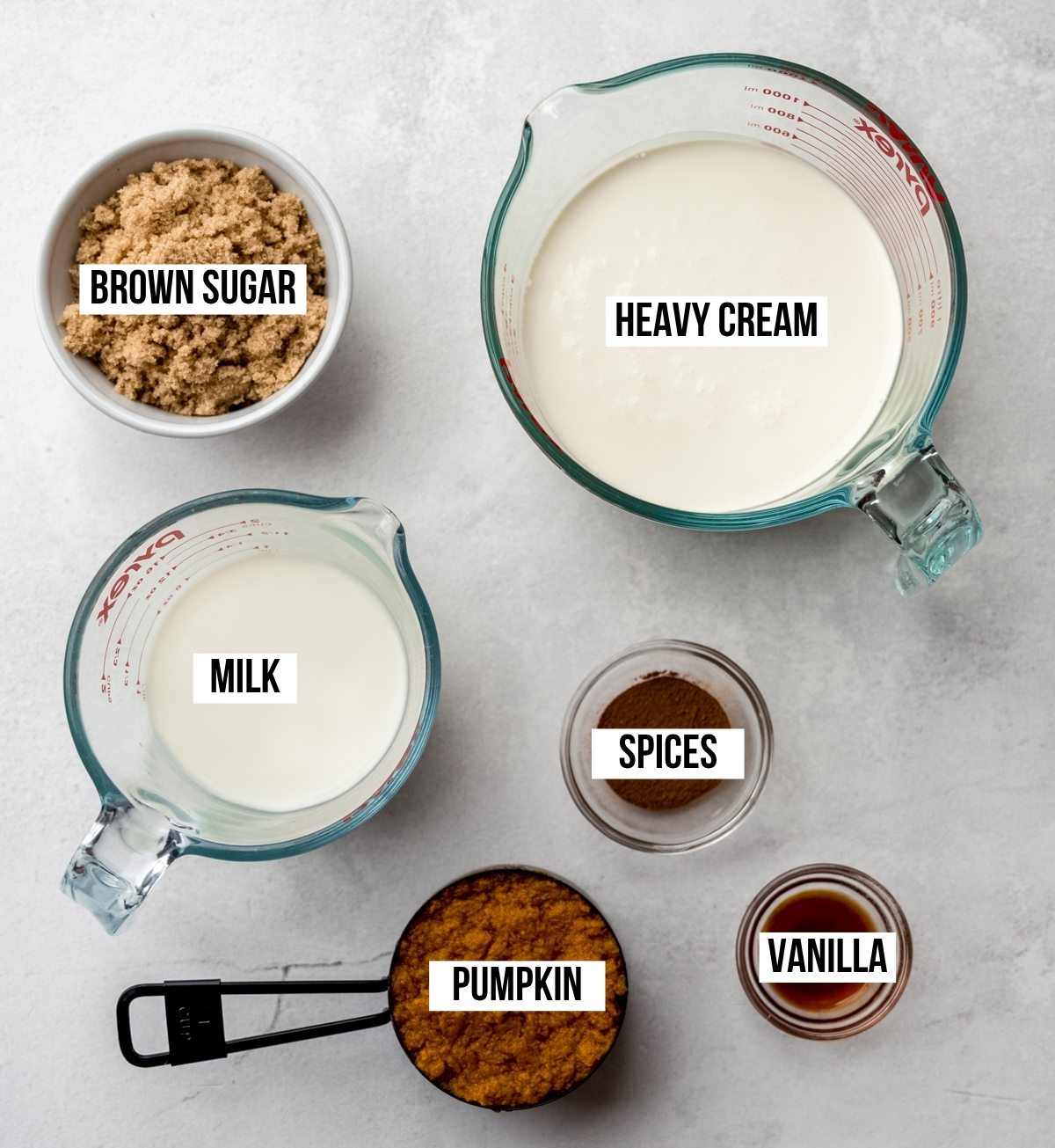Aerial photo of the ingredients to make pumpkin ice cream with text overlay labeling each ingredient.