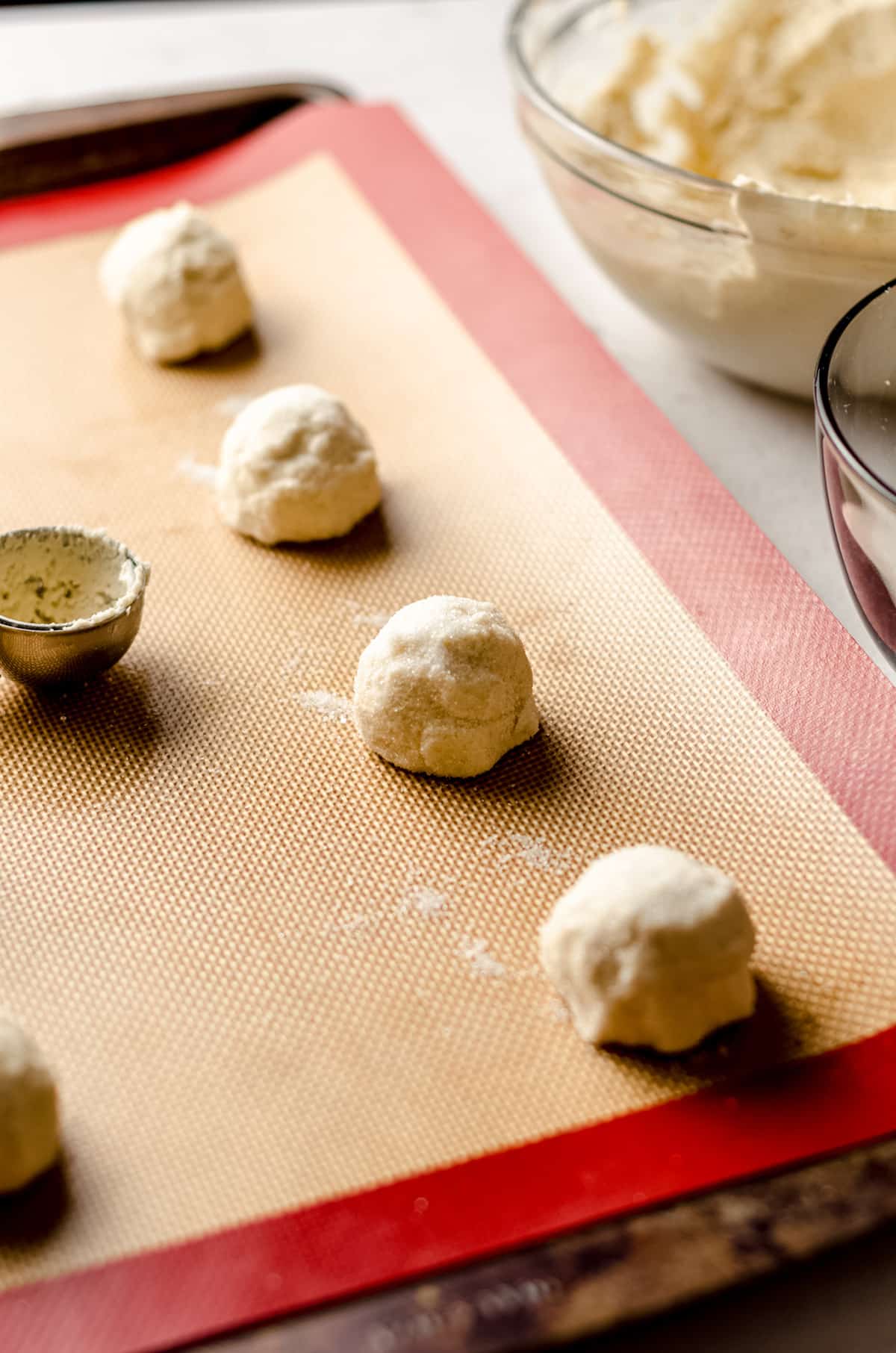 balls of vanilla bean sugar cookie dough on a baking sheet