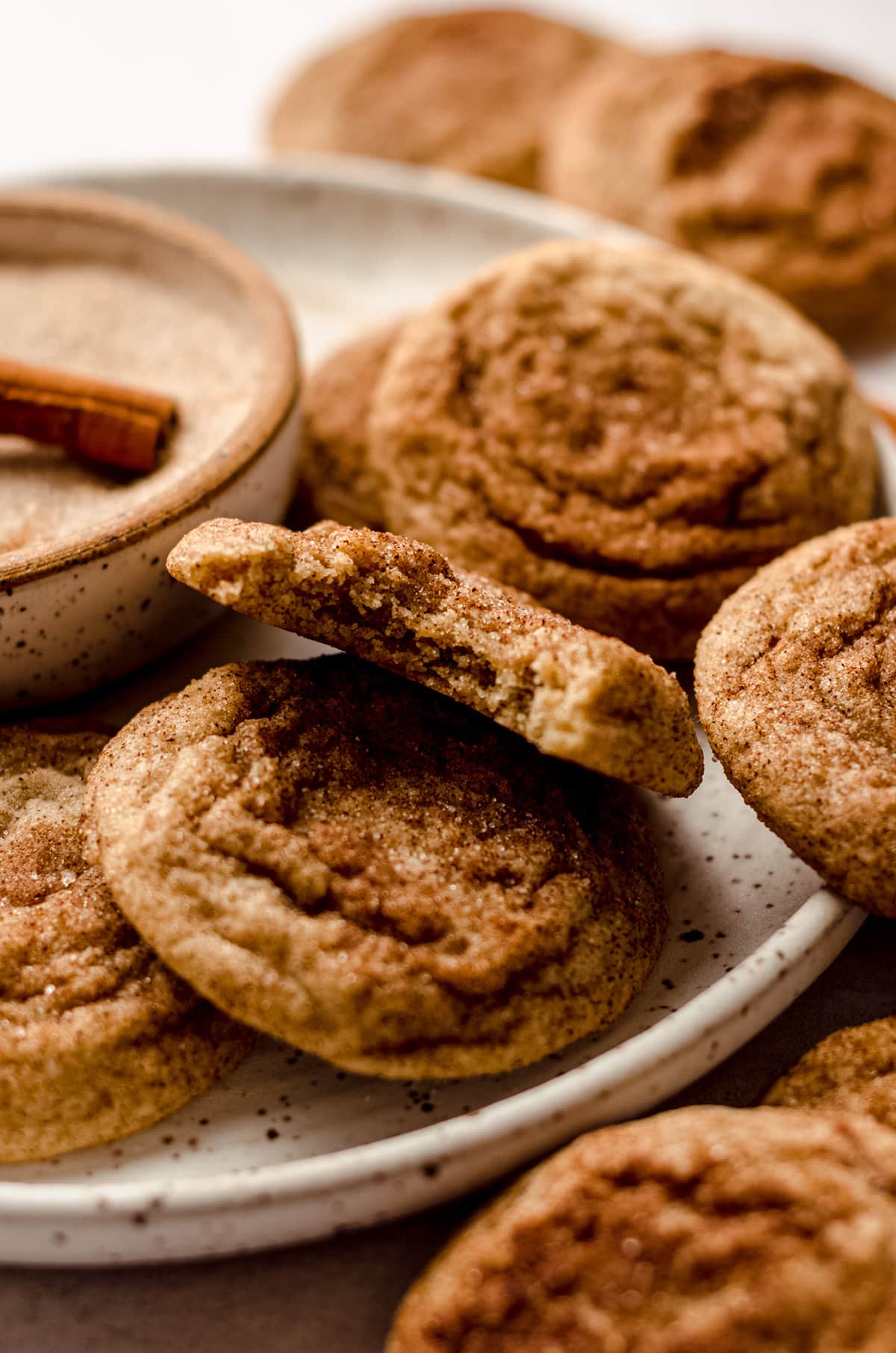 soft and chewy snickerdoodles on a plate and one has a bite taken out of it