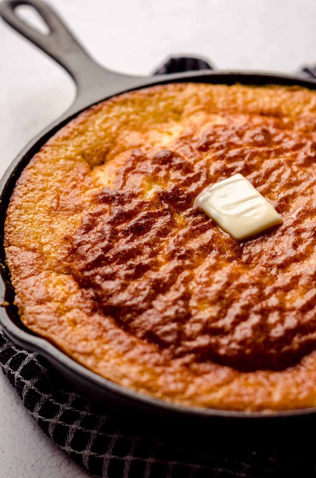 skillet cornbread with a pat of melting butter on top of it