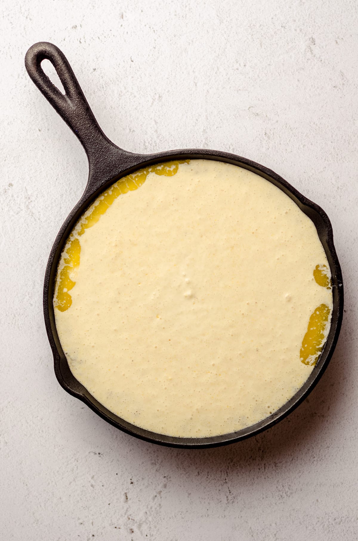 aerial photo of homemade cornbread batter in a prepared skillet