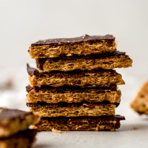 A stack of piece of graham cracker toffee bark on a surface.
