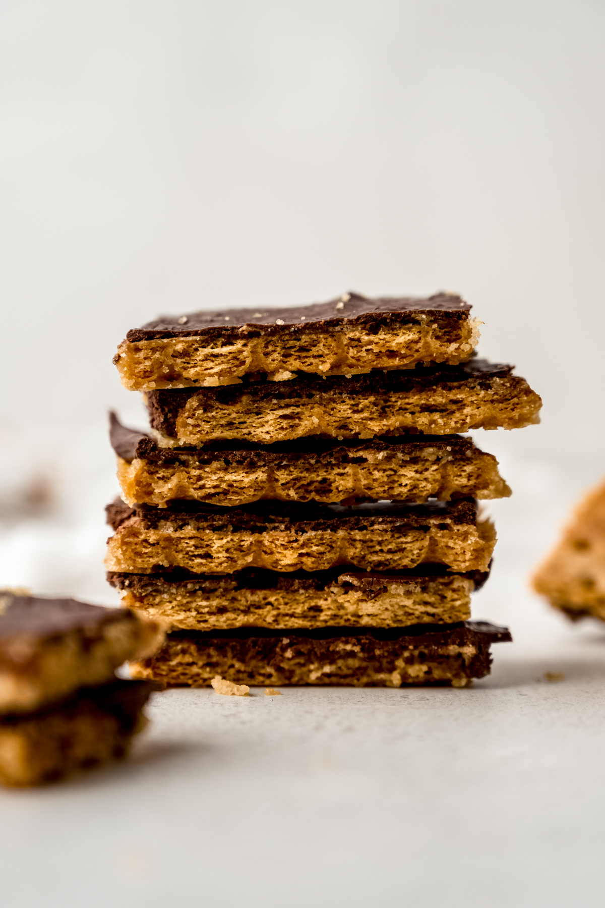 A stack of piece of graham cracker toffee bark on a surface.