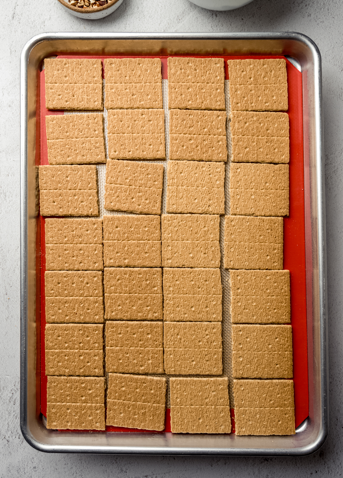Aerial photo of a baking sheet lined with graham cracker squares.