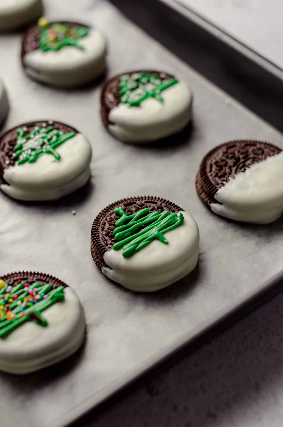 green trees piped onto white chocolate dipped oreos