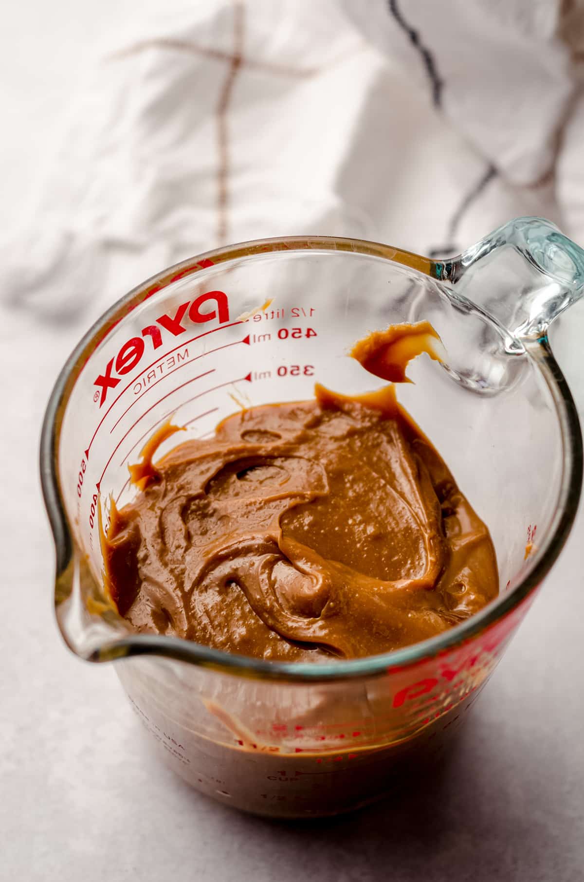 homemade dulce de leche in a measuring cup