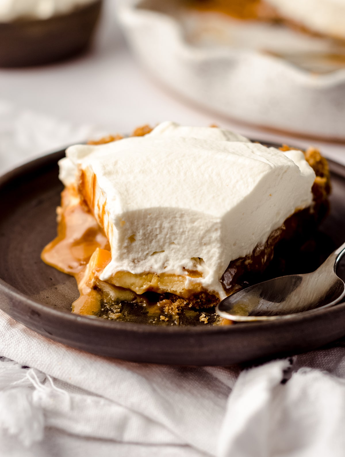 slice of banoffee pie on a plate with a bite taken out of it