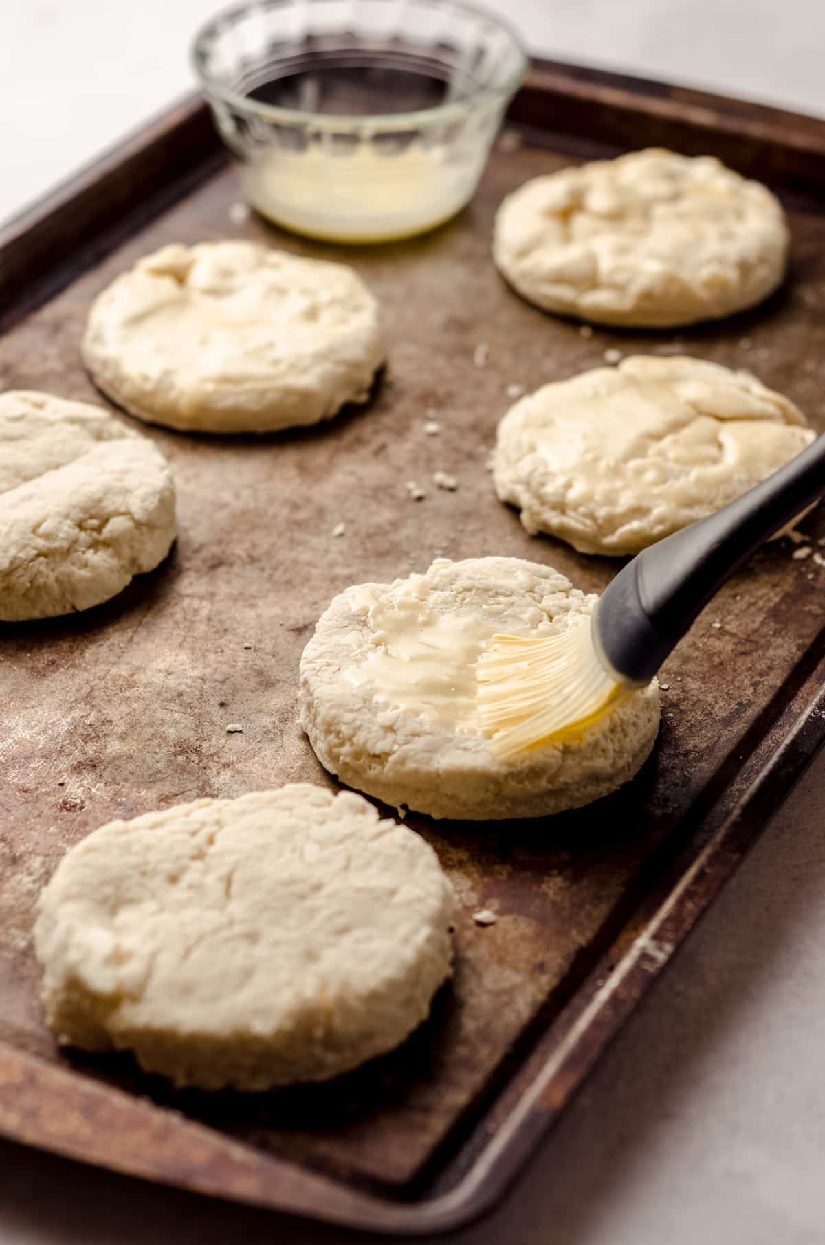 brushing a biscuit with butter