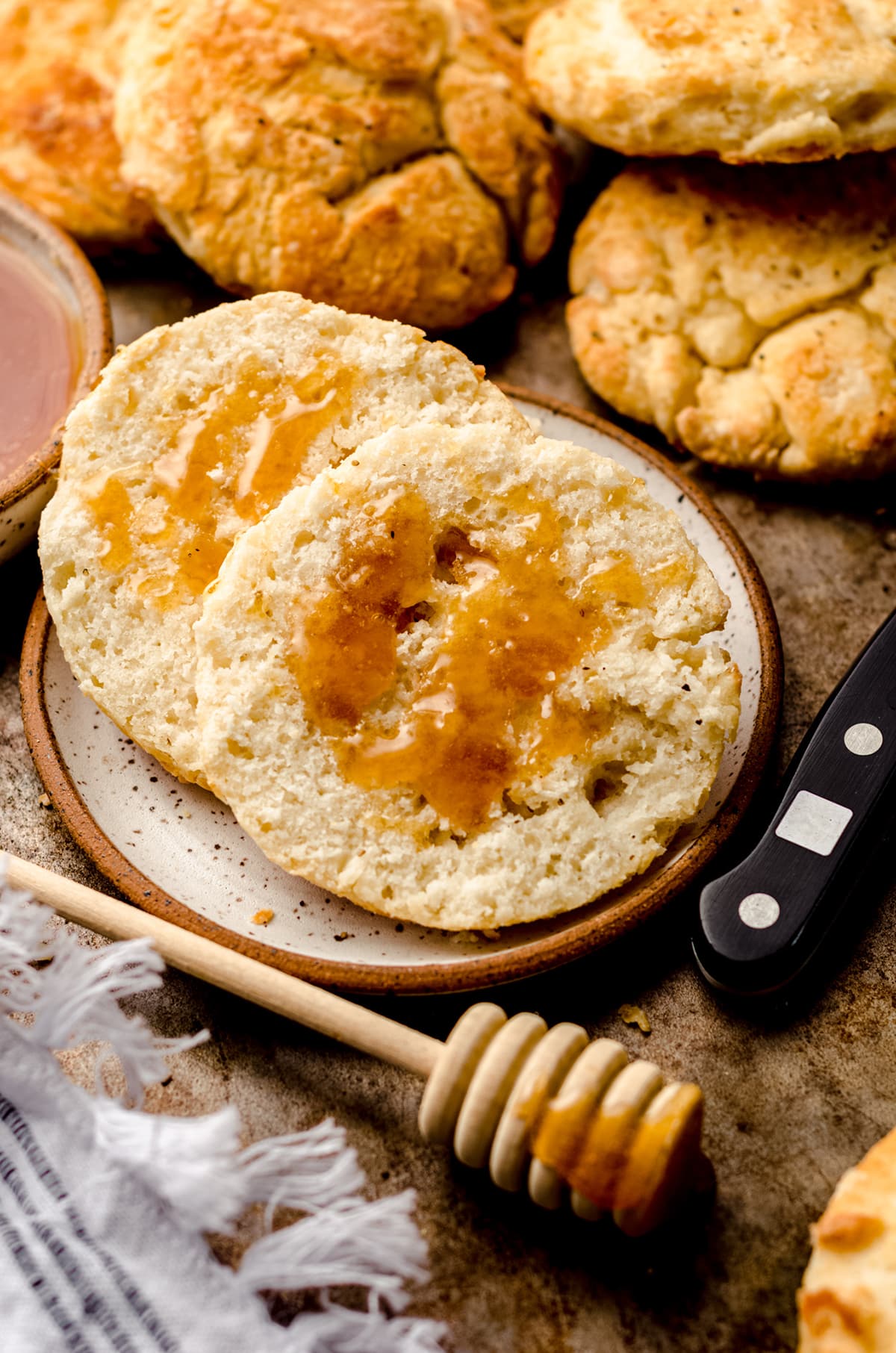 a biscuit on a plate with honey drizzled on it