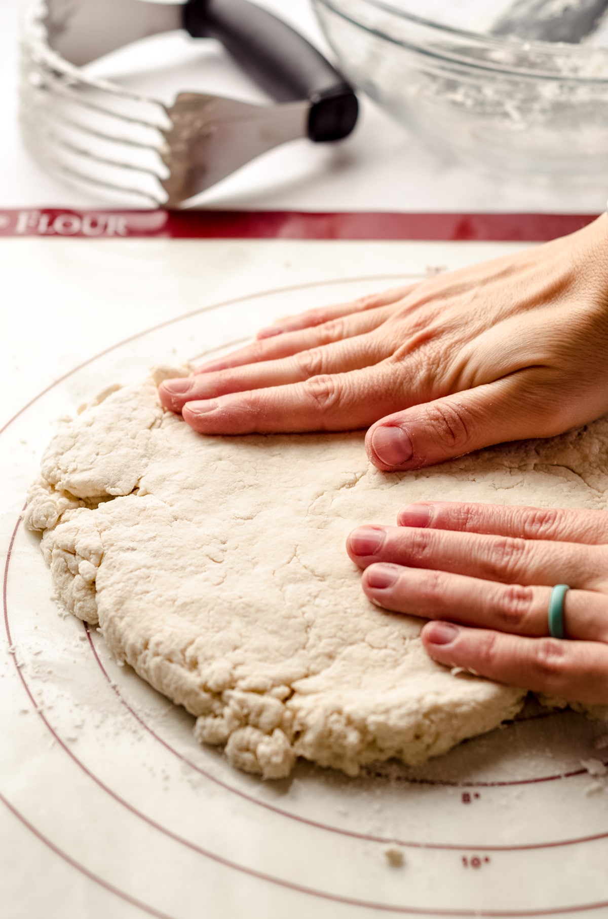 hands patting biscuit dough