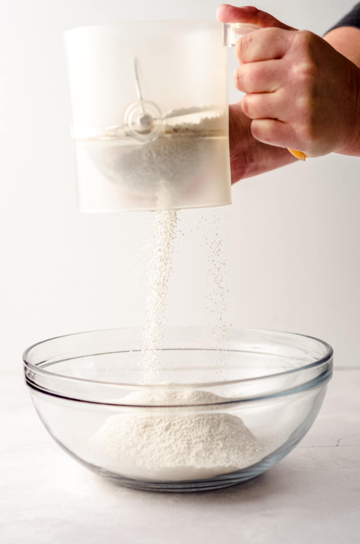 sifting flour and dry ingredients together into a bowl