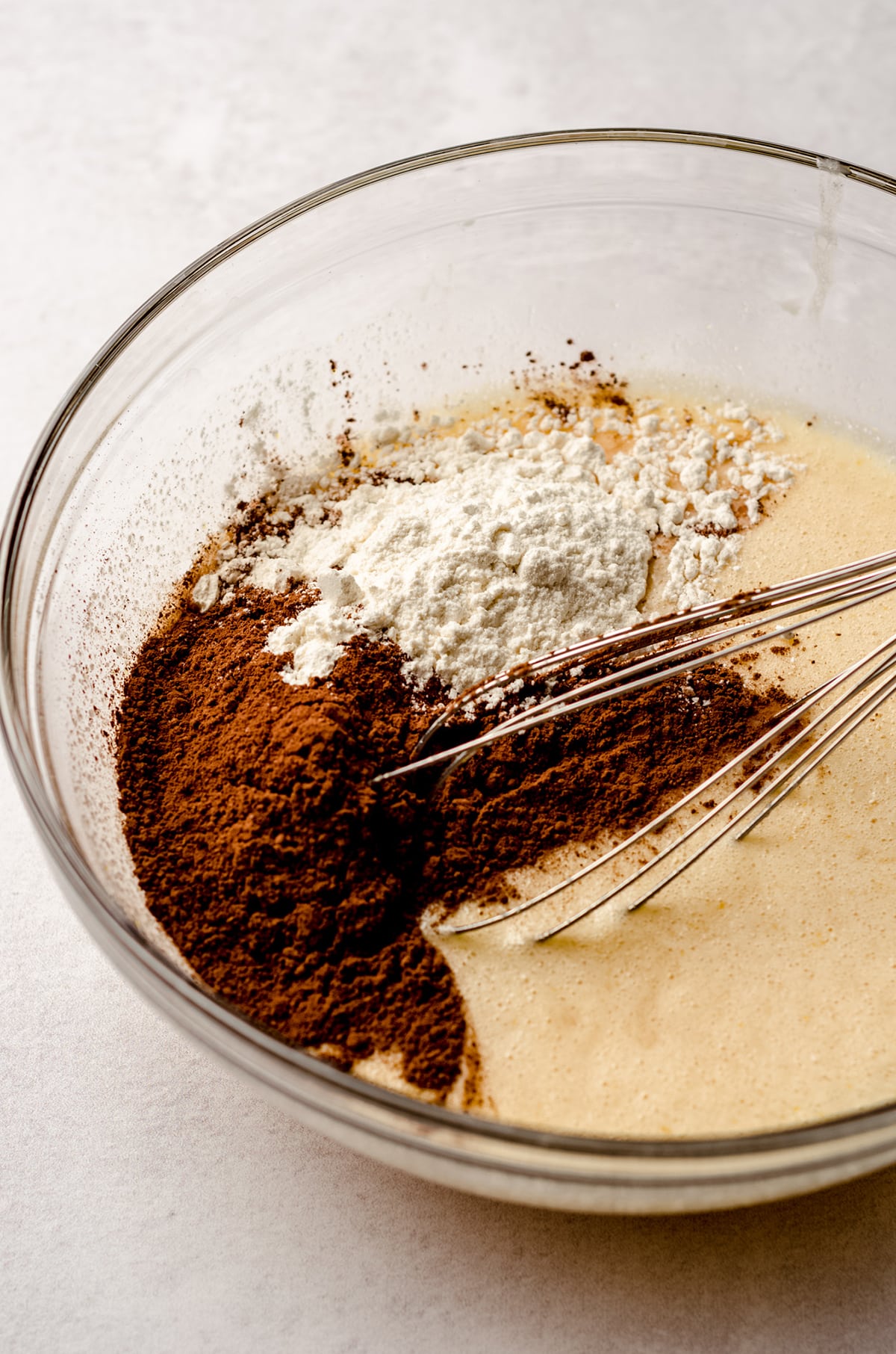 ingredients for chocolate chess pie in a bowl with a whisk