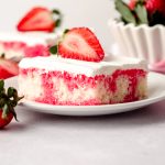 slice of strawberry poke cake on a plate