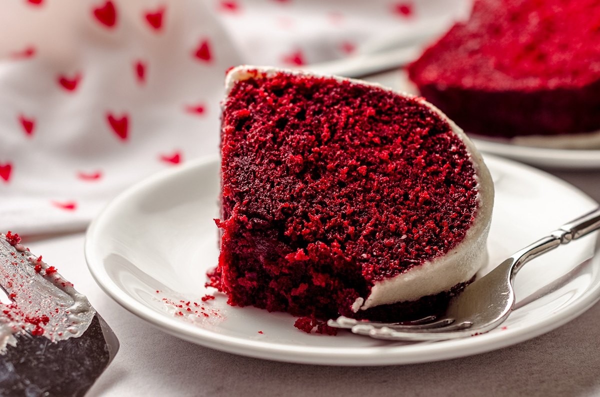slice of red velvet bundt cake on a plate with a bite taken out of it