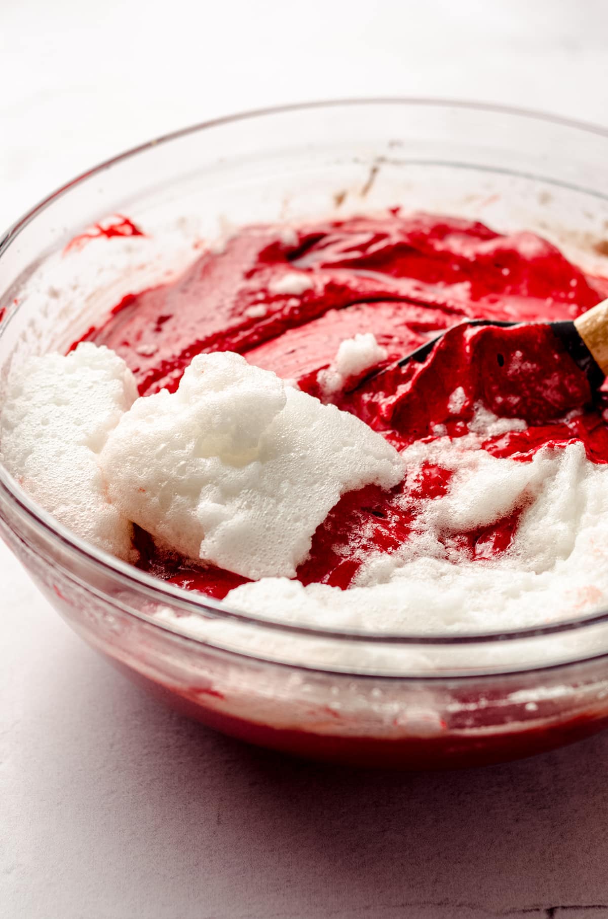 folding whipped egg whites into red velvet cake batter