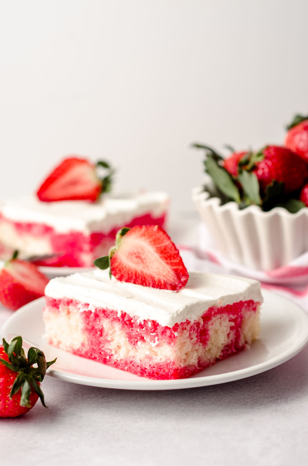 slice of strawberry poke cake on a plate