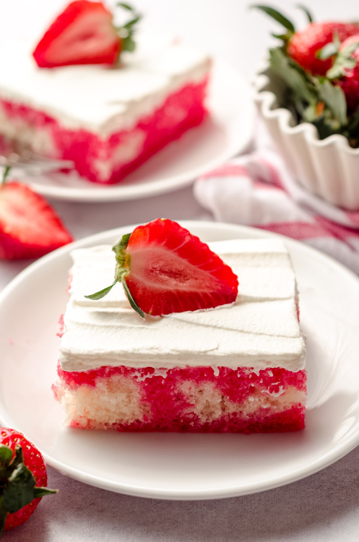slice of strawberry poke cake on a plate