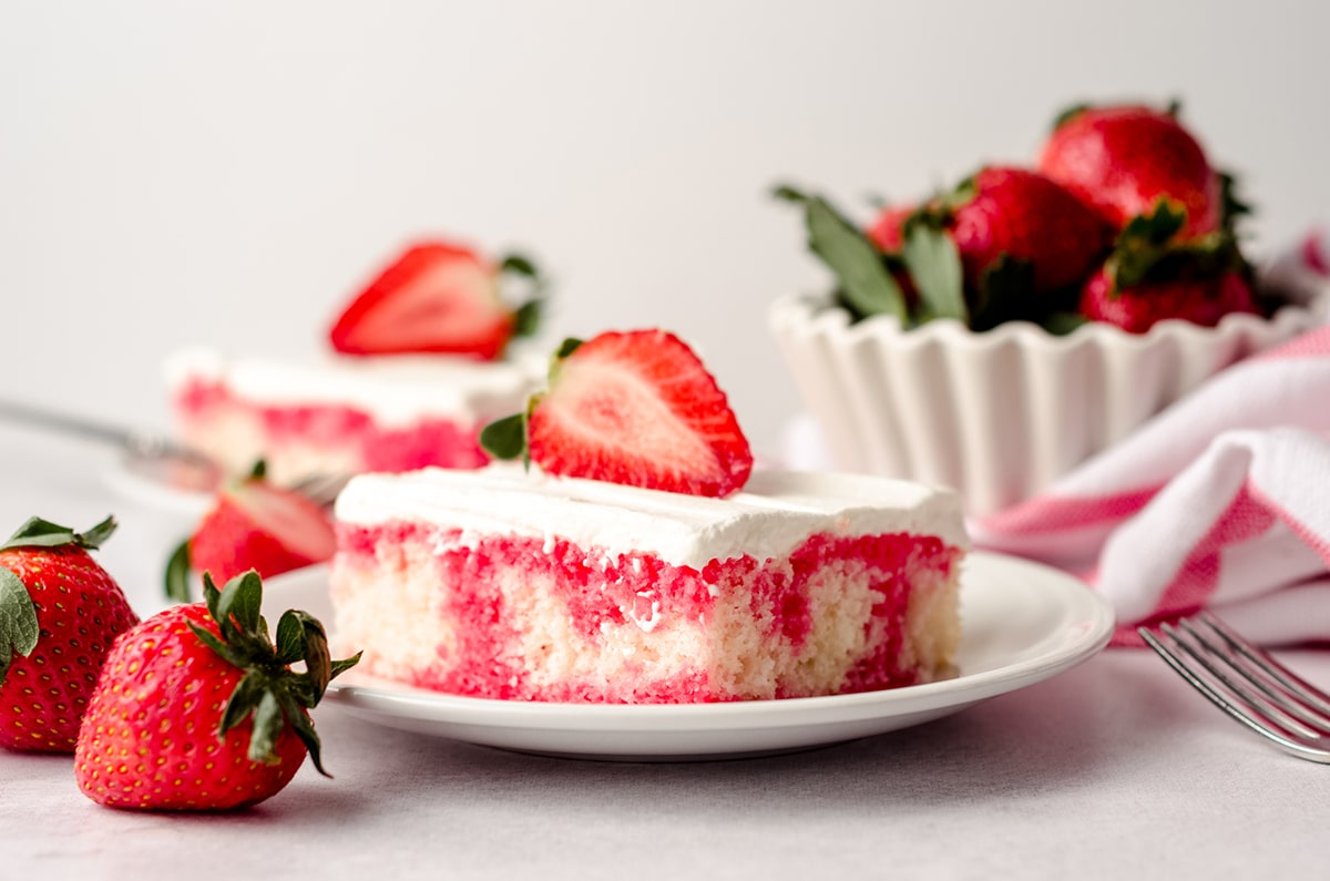 slice of strawberry poke cake on a plate