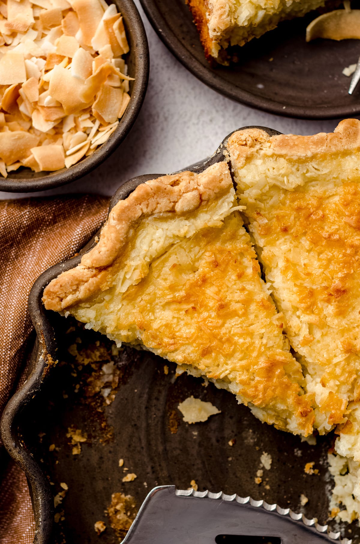 A pie dish with several slices of pie, and a small serving utensil on the side.