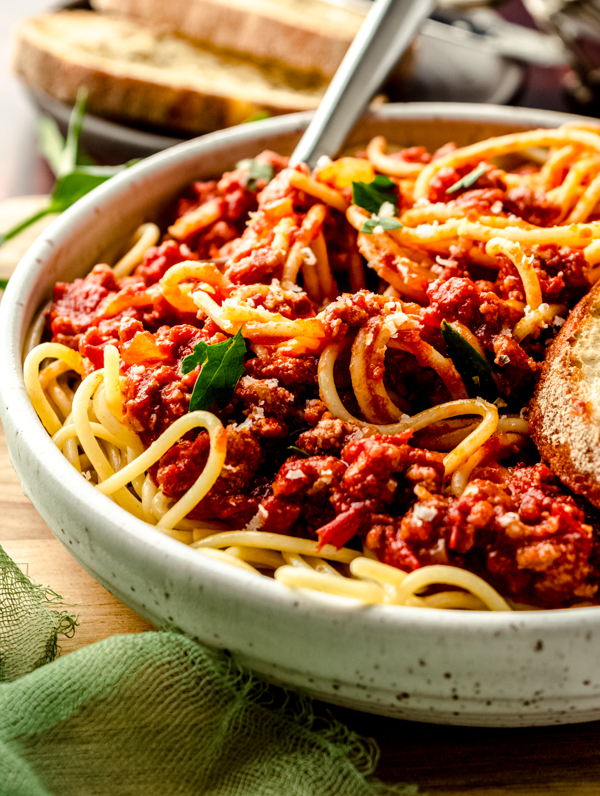 A bowl of pasta with homemade meat sauce on it. There is a fork in the bowl.