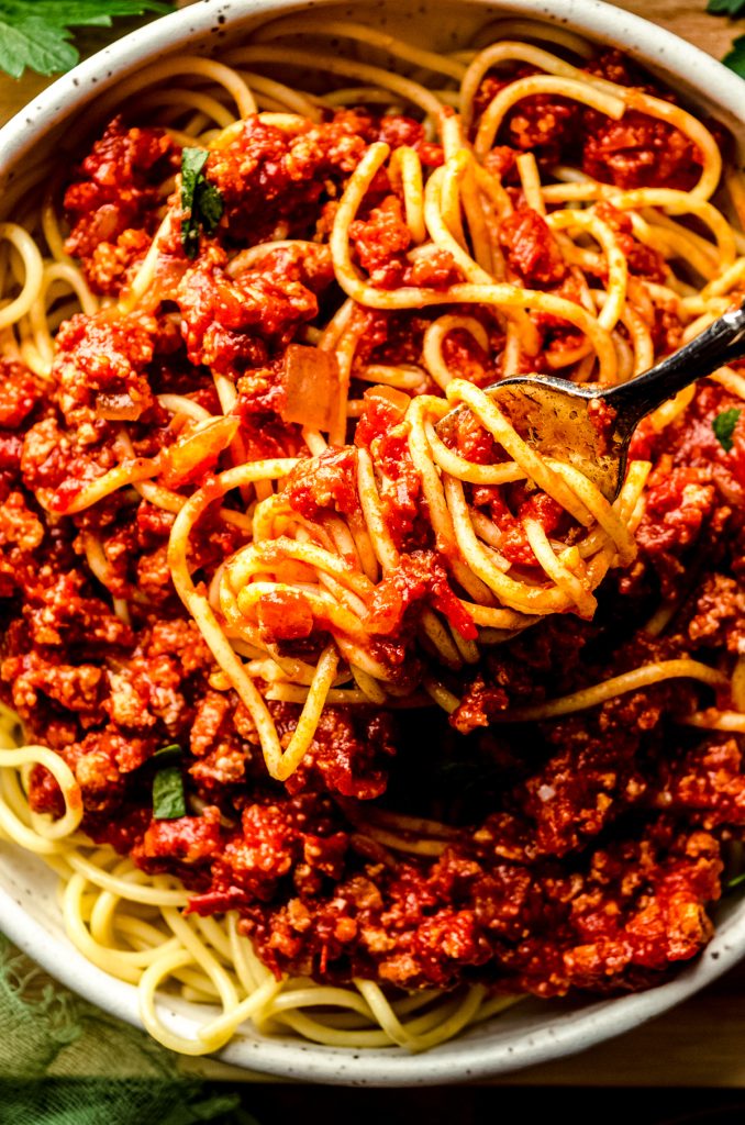 A forkful of spaghetti with meat sauce on it.