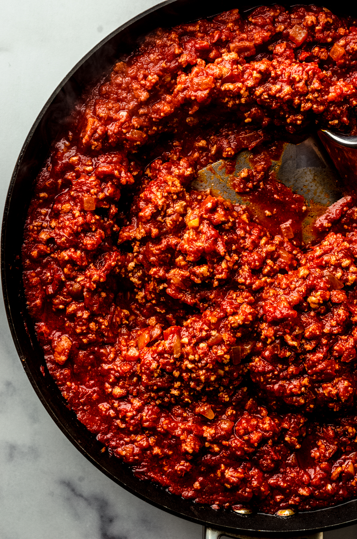 Homemade meat sauce in a saucepan with a large spatula.