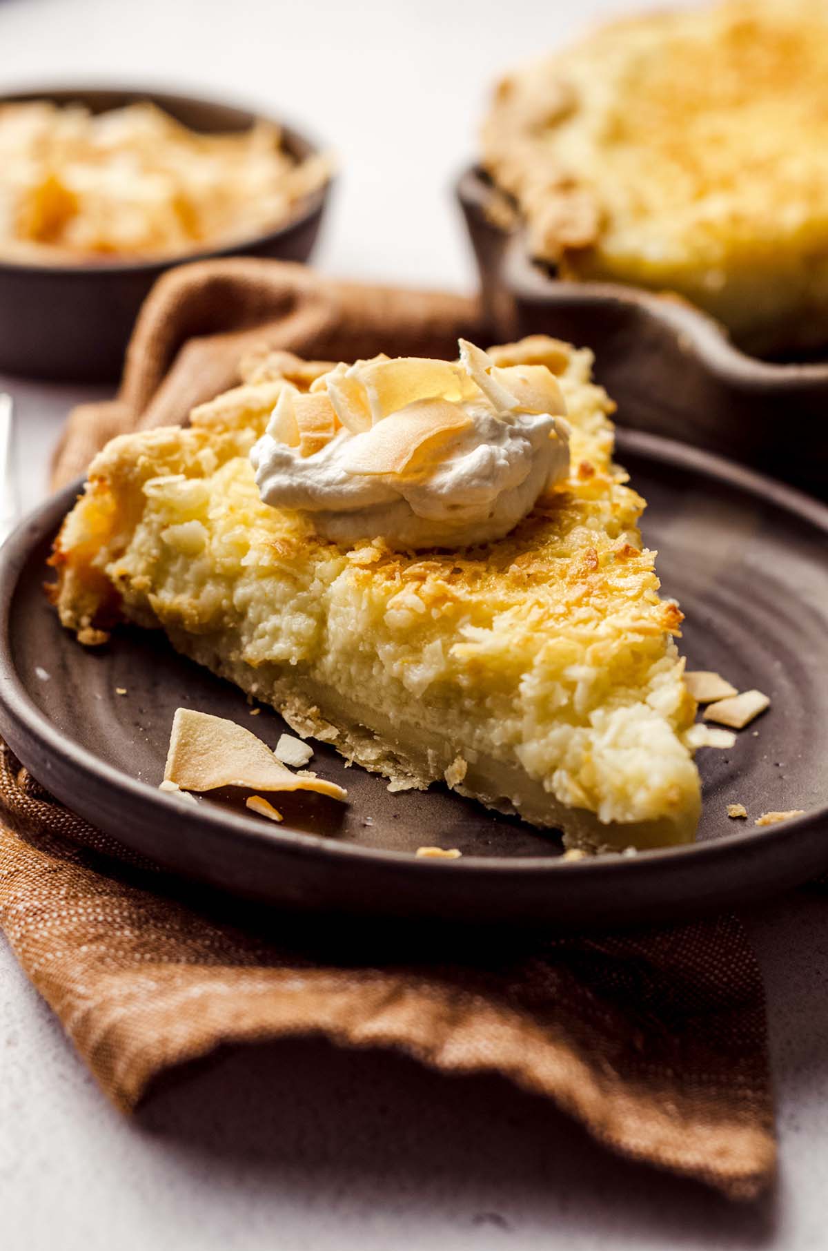 A slice of pie with a dollop of whipped cream on a plate.