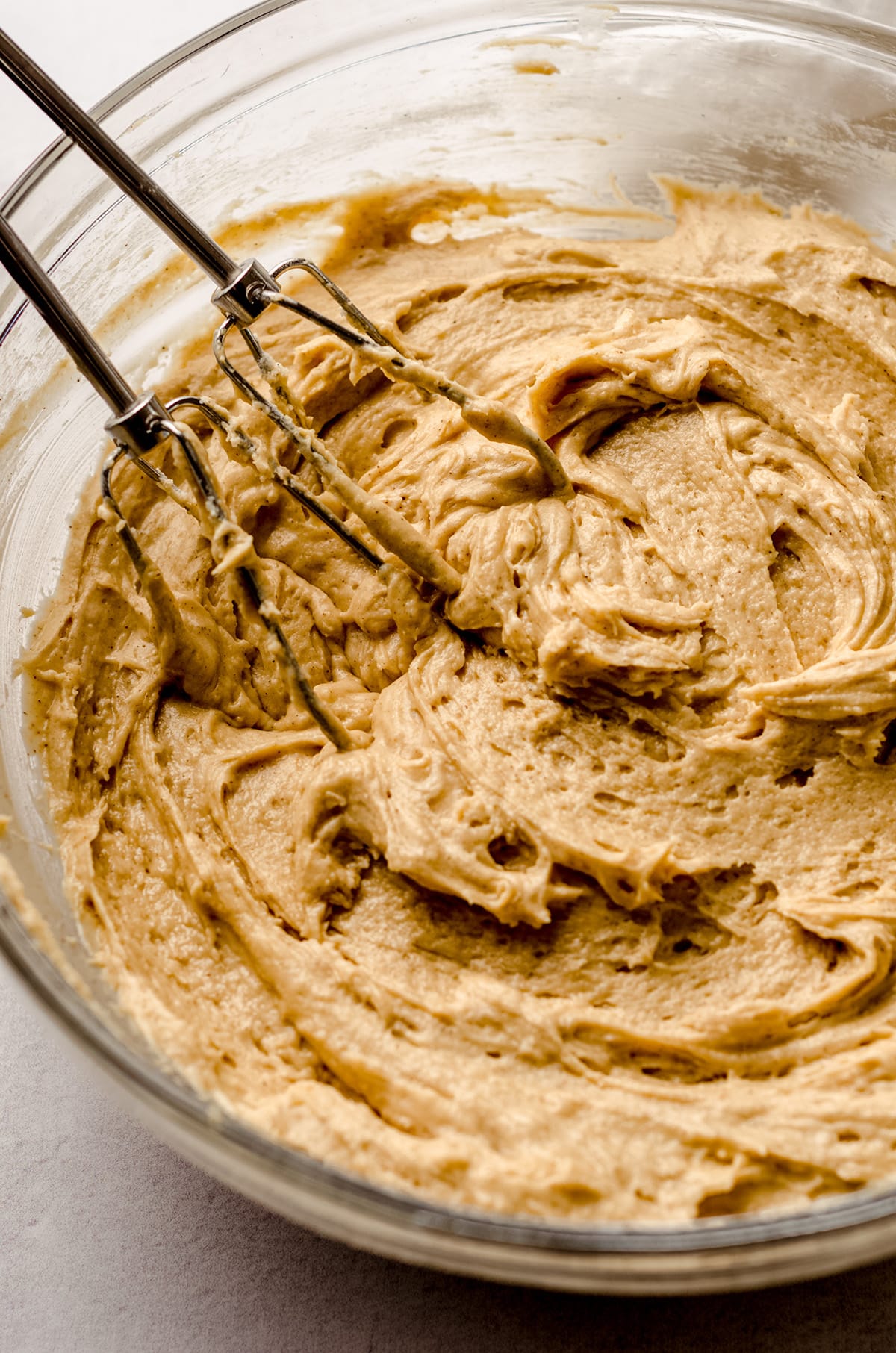 cinnamon coffee cake batter in a bowl with beaters