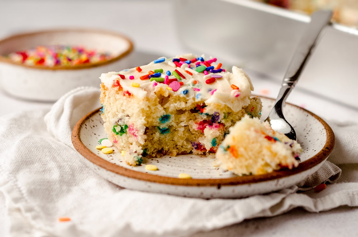 A single square of vanilla cake with sprinkles.