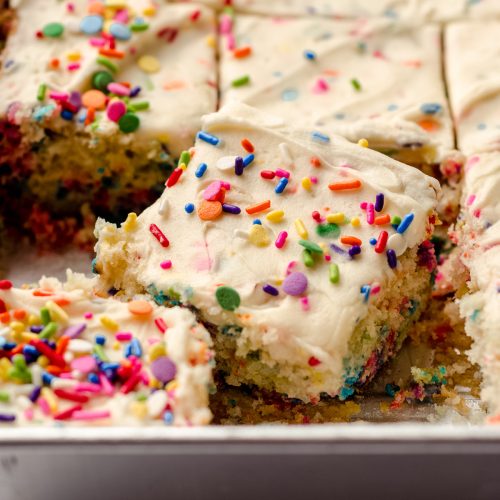 A baking pan filled with sheet cake, topped with sprinkles.