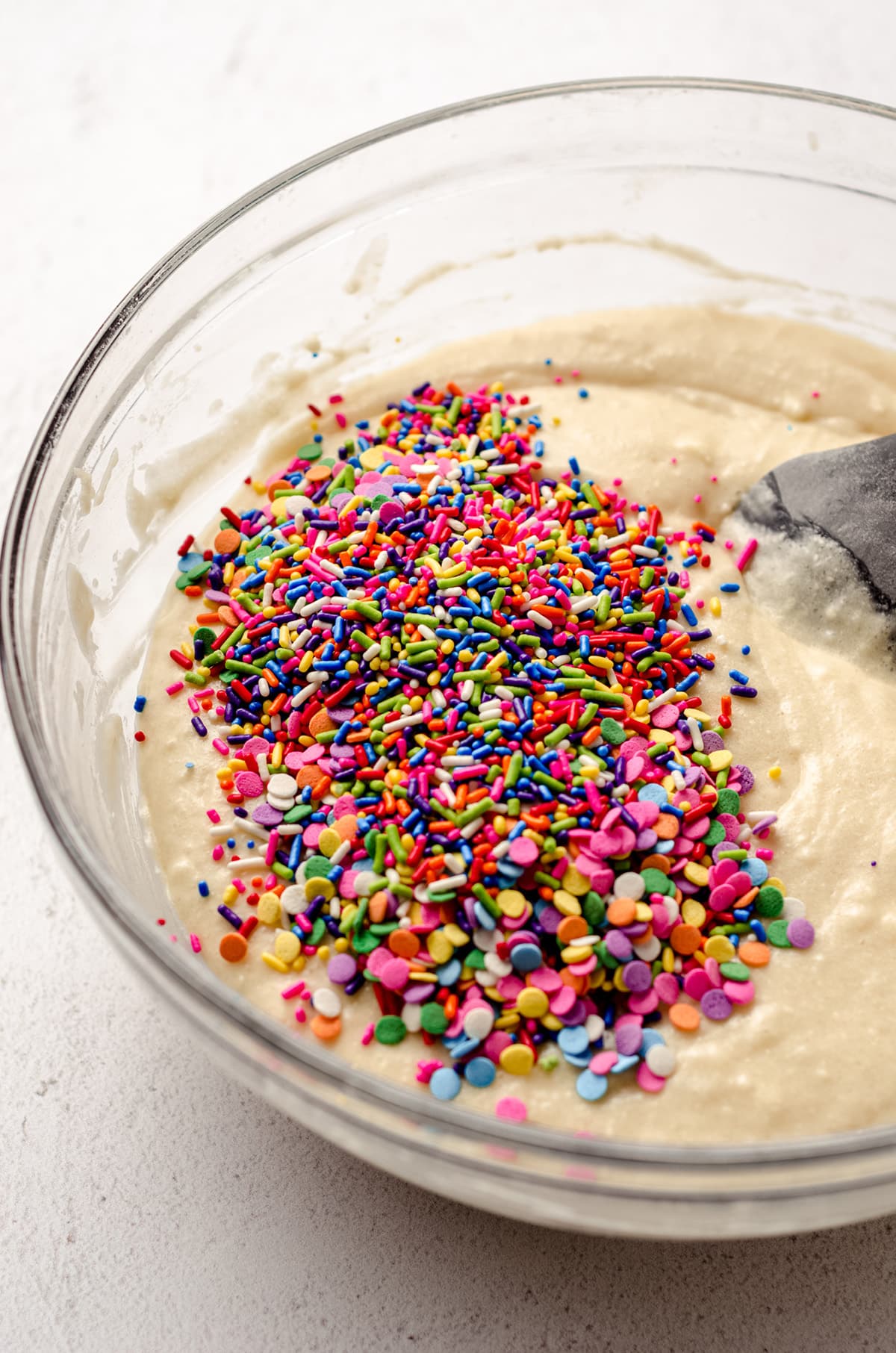 A bowl of cake batter with sprinkles added in.